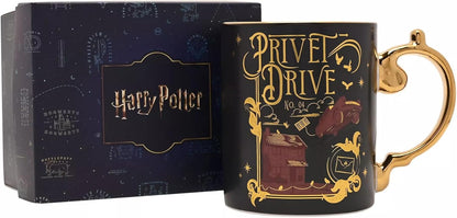 A black Harry Potter Privet Drive No. 04 ceramic mug with a gold handle and gold printed illustration, shown next to its dark blue branded gift box.