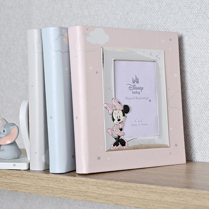 Pink photo frame with Minnie Mouse design on a shelf against a light gray wall.