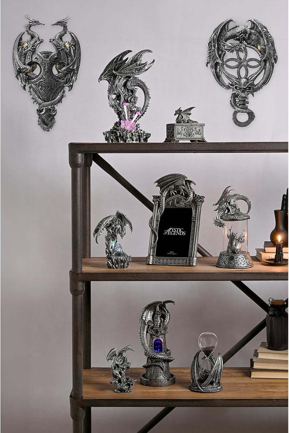 Collection of dragon-themed decorative items on a wooden shelf against a gray wall.