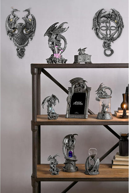 Collection of dragon-themed decorative items on a wooden shelf against a gray wall.