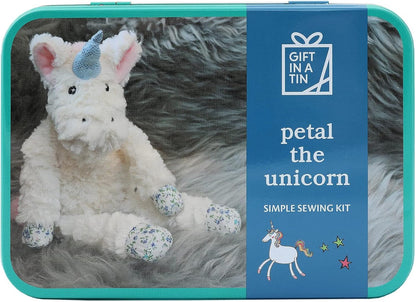 Unicorn plush toy in a tin with 'Gift in a Tin' branding and text about a sewing kit.