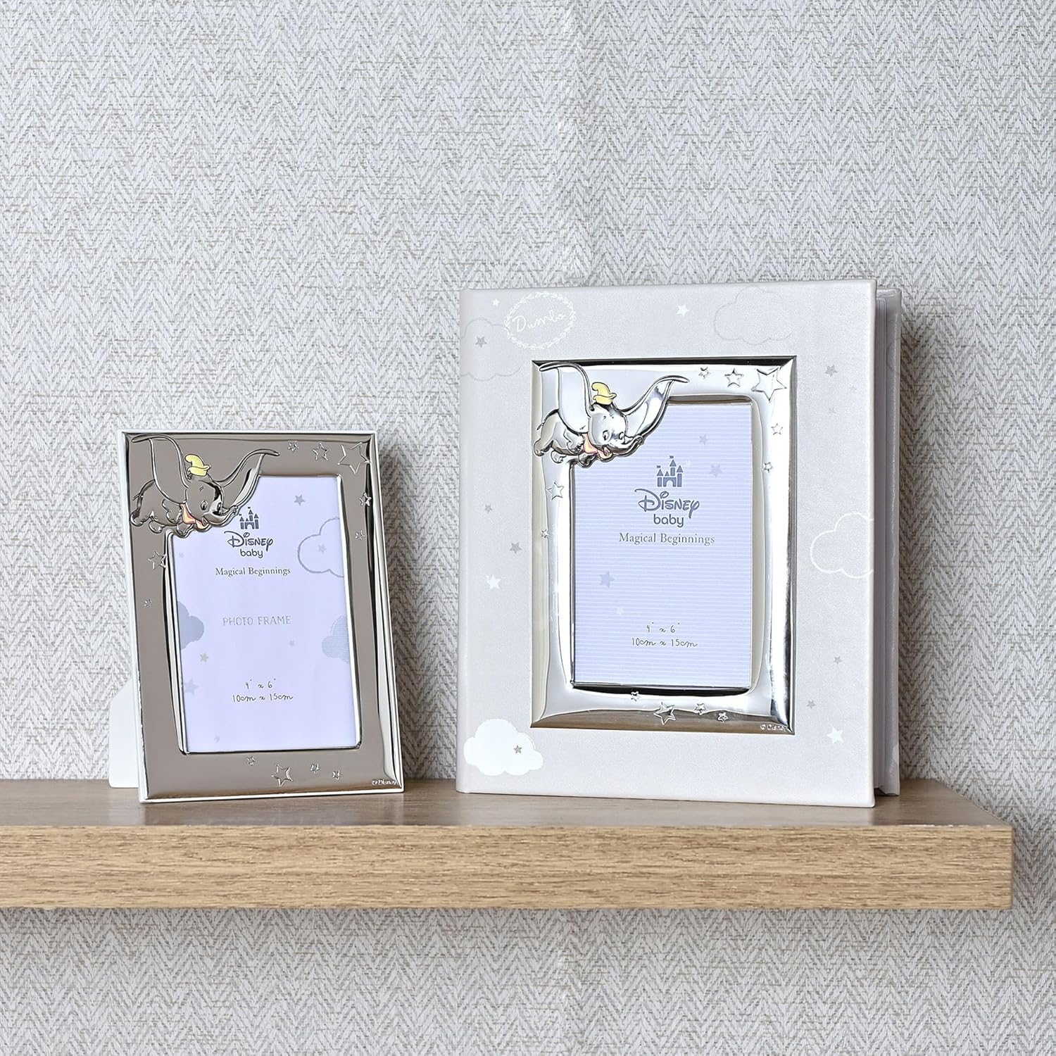 Two decorative photo frames with elephant designs on a wooden shelf against a textured wall.