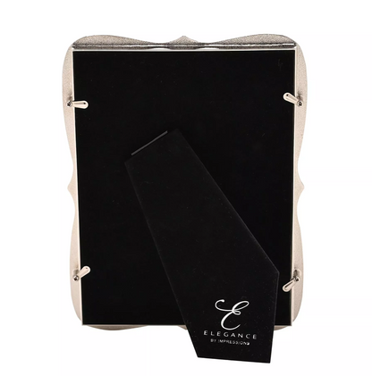 Black back of frame with 'Elegance by impressions' branding in a beige holder on a white background
