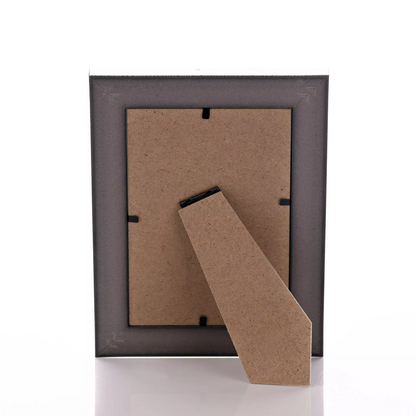 Dark wooden picture frame with a cardboard backer on a white background