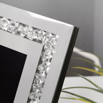 Decorative photo frame with crystal embellishments on a neutral background