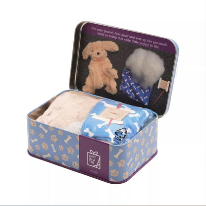 Toy assembly kit with plush dog and stuffing in a decorative tin box.