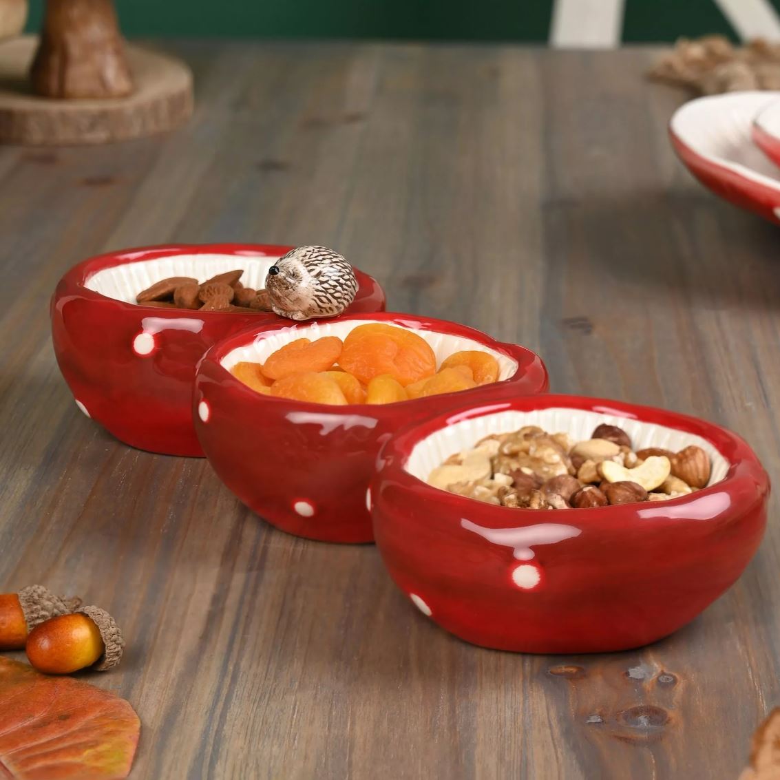 Three red ceramic bowls with food on a wooden table