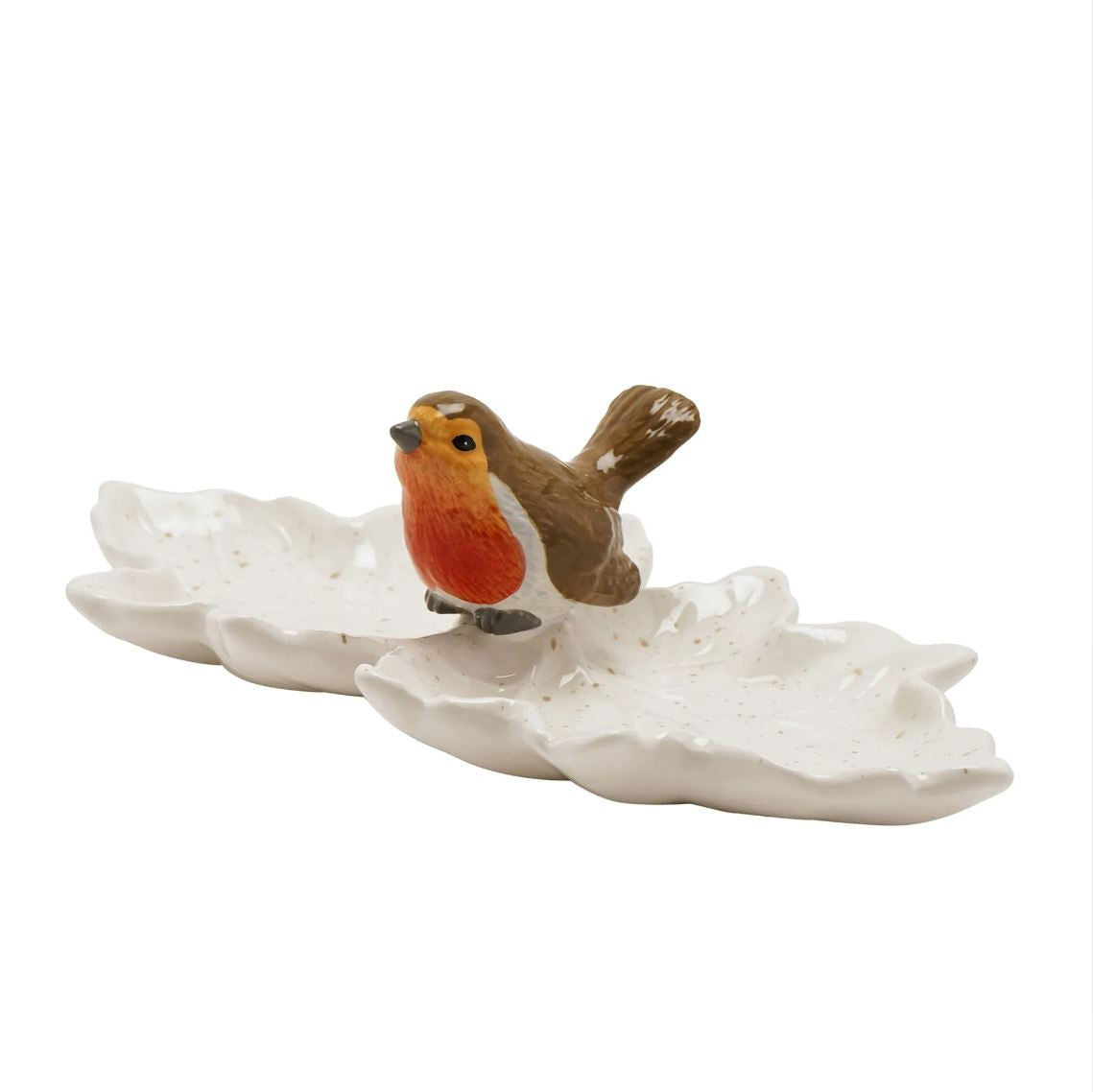 A small robin bird figurine perched on a white leaf-shaped dish, photographed against a plain white background.