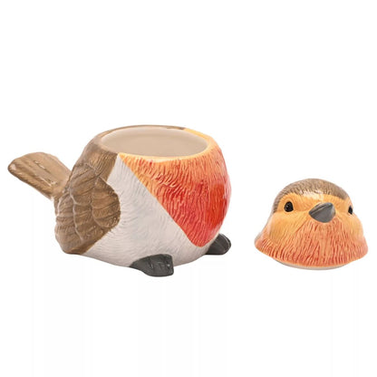 A bird-shaped ceramic Biscuit tin with a matching bird-shaped lid placed beside it on a plain white background. Its shaped like a robin or similar small bird, with brown wings, a white body, and a reddish-orange chest, while the lid shows the bird's head with a peachy-orange beak and brown top.