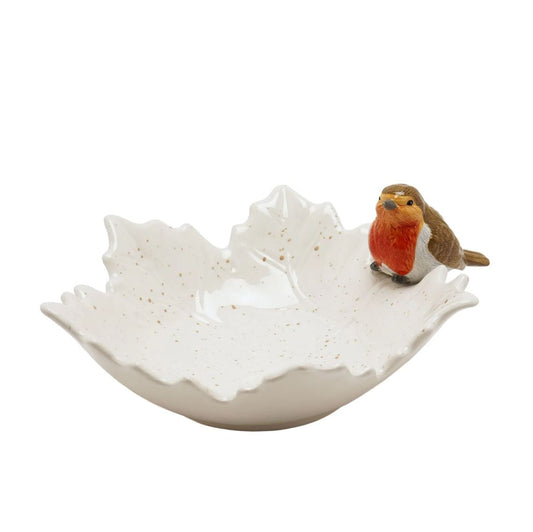 A white ceramic bird bath shaped like a leaf, decorated with small gold speckles and featuring a small robin figurine perched on the right side, set against a plain white background.