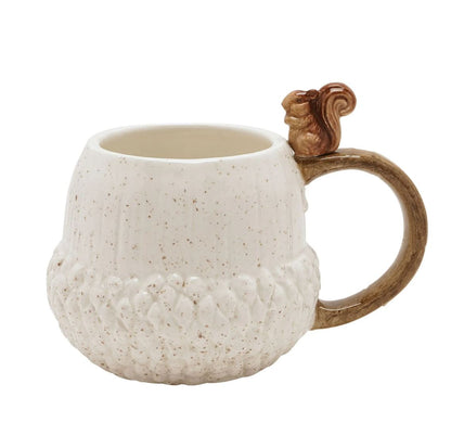 An acorn-shaped ceramic mug with a textured cream-white body, brown speckles, a brown handle, and a small sculpted squirrel on top of the handle, shown on a plain white background.