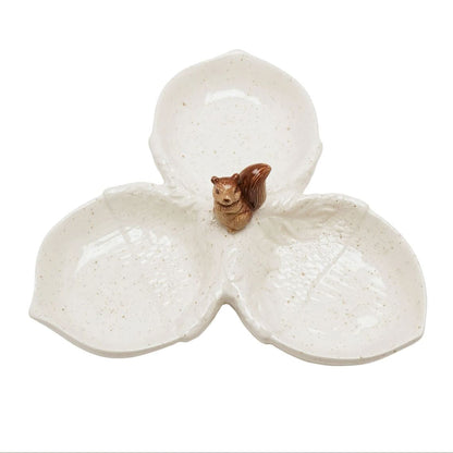A three-petal ceramic dish with a small brown squirrel figurine in the center, set against a plain white background.