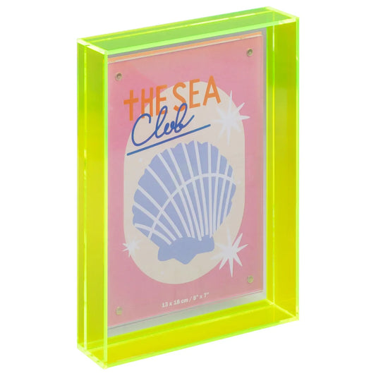 A neon yellow-green acrylic picture frame holding a pink art print with a blue seashell illustration and the words 'THE SEA Club'.