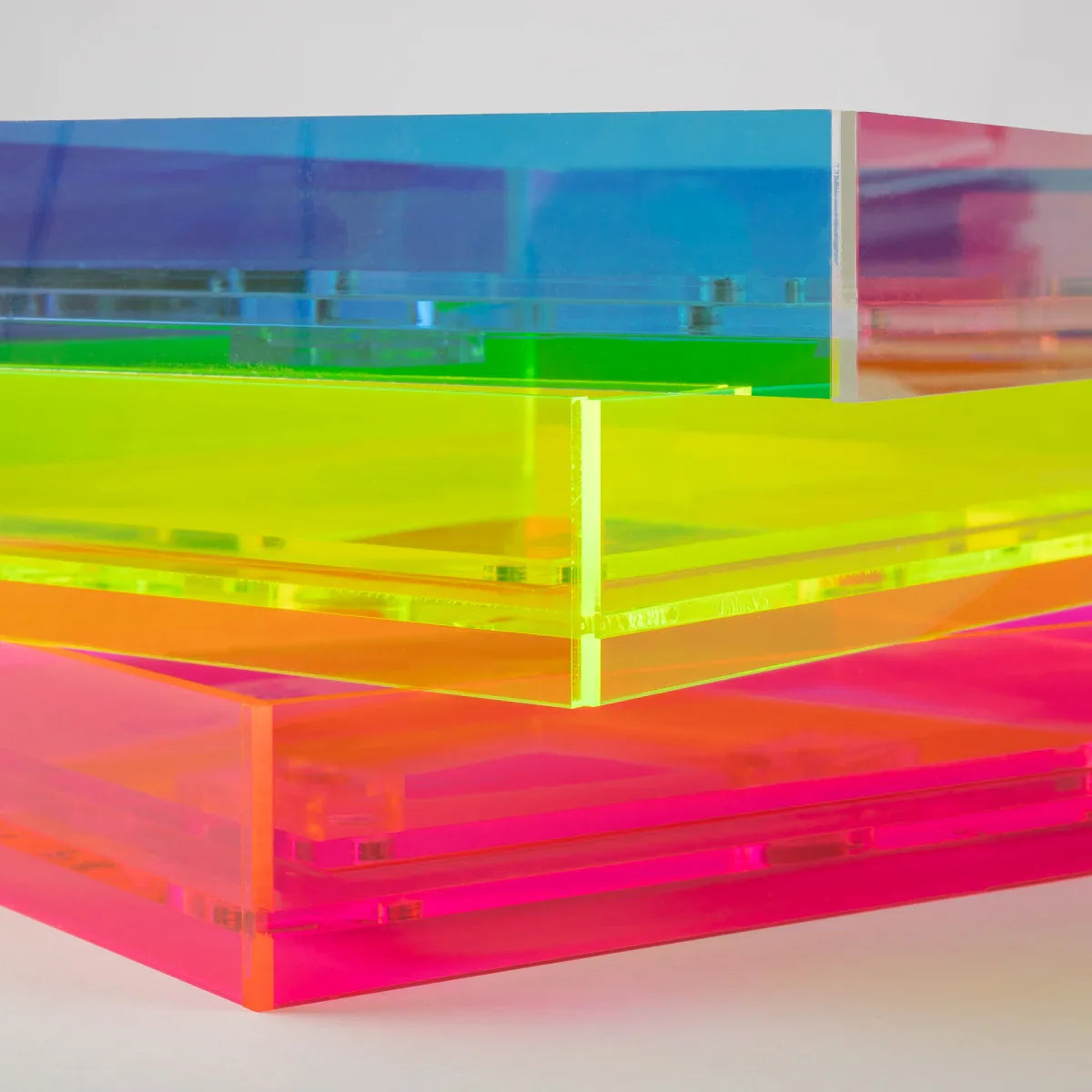 Stacked translucent acrylic frames in a rainbow colour sequence, including blue, green, yellow, orange, and pink, on a light grey background.